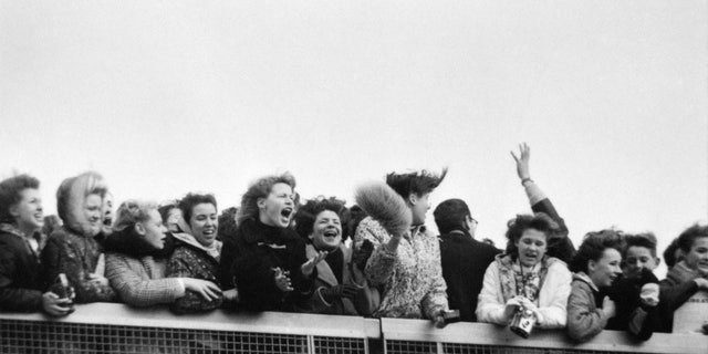 NEW YORK - FEBRUARY 7: Fans scream with excitement at the arrival of The Beatles at John F. Kennedy International Airport, Feb. 7, 1964.