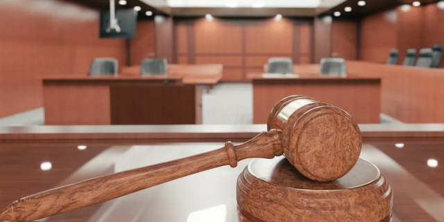 Inside a courtroom with gavel in plain view.