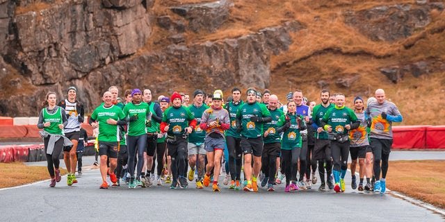 McKee (second from right, front, in green shirt) saw multiple people complete their first marathon after they ran alongside him during his.