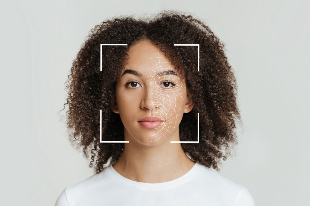 A woman's face with dark curly hare with a focus square over her face mimicking facial recognition software