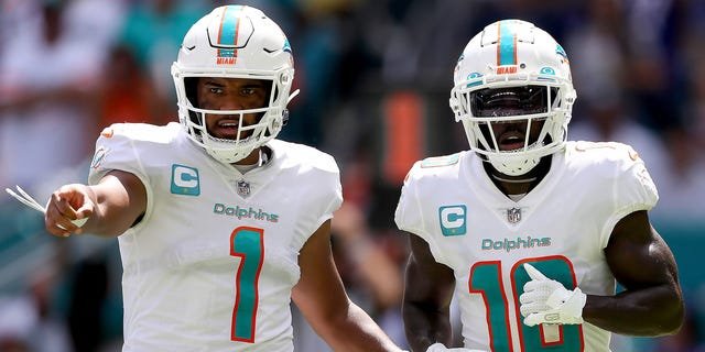 Tua Tagovailoa (1) and Tyreek Hill (10) of the Miami Dolphins in action during the first half of a game against the Buffalo Bills at Hard Rock Stadium Sept. 25, 2022, in Miami Gardens, Fla.