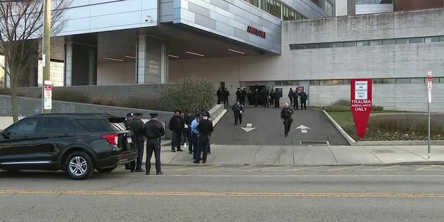 Philadelphia police officers gather outside a hospital where a fellow officer was taken after being shot.