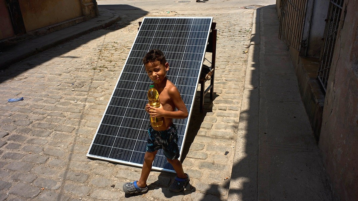 boy holidng oil bottle near solar panel